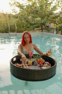 a woman in a swimming pool with a tray of food at Zebra in Tivat