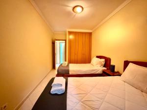 a hotel room with two beds and a window at Renaissance Sunrise Inn Algarve in Portimão