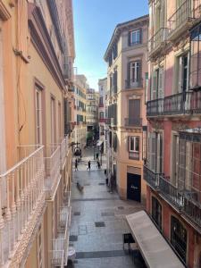 a city street with buildings and people walking down it at Catedral Larios Centro in Málaga