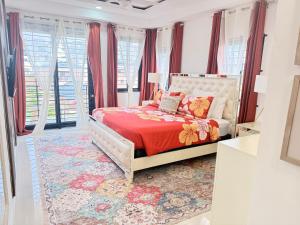 a bedroom with a bed with a red comforter at Palms Rooftop Villa in Ocho Rios