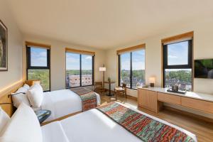 a hotel room with two beds and a bathroom with windows at The Compton in Bentonville