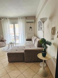 a living room with a couch and a table at Artemis apartment in Nea Peramos +26 photos