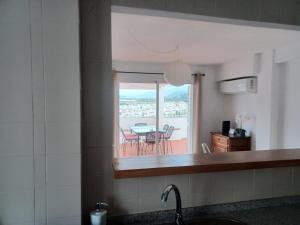 a kitchen with a view of a table and a balcony at Ático en Estepona, Malaga in Estepona +12 photos