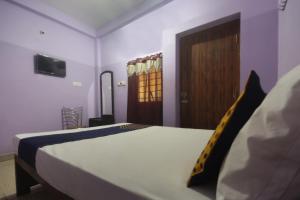 a bedroom with a bed and a wooden door at Hotel O by OYO Kb Residency in Kurinjippādi