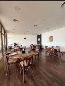 a restaurant with wooden tables and chairs in a room at Samarah EP 04 full Sea View and poll access prime location with big terrace, in Sowayma