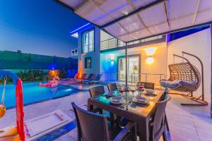 a dining room with a table and chairs and a pool at Villa adelina in Çavdır