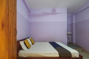 a bedroom with a bed with yellow and blue pillows at Hotel O by OYO Kb Residency in Kurinjippādi