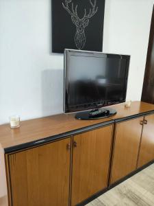 a flat screen tv sitting on top of a wooden cabinet at Casa Rural "Baru" in Alpandeire