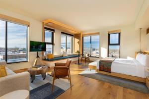 a bedroom with a bed and a living room with windows at The Compton in Bentonville