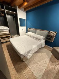 a bedroom with a large bed with a blue wall at Vicoletto4-Centro storico Verona con Parking in Verona