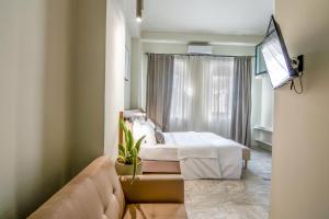 a hotel room with a bed and a couch at OIKO MINI SUITES in Ermoupoli