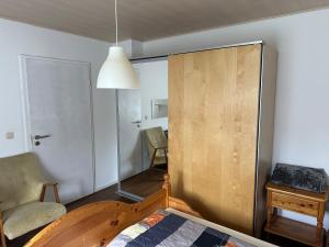 a bedroom with a wooden cabinet and a chair at Idyllische Wohnung in ruhiger Lage Nähe BAB A6! in Illschwang