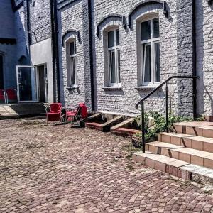 a brick building with red chairs and a patio at Hostel Kamienna Centrum in Katowice