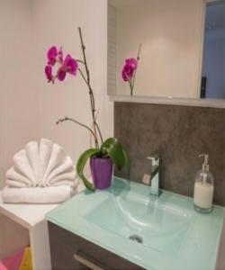a bathroom with a sink with a vase with flowers at La Roche aux Fées in Lapte +20 photos