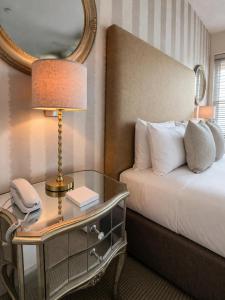 a hotel room with a bed and a table with a phone at Crescent Victoria Hotel in Margate