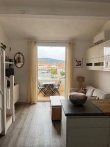 a kitchen and living room with a view of a patio at Nid du port in Grimaud +10 photos