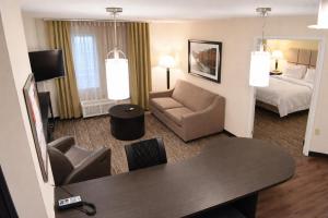 a hotel room with a bed and a table and chairs at Candlewood Suites MORGANTOWN-UNIV WEST VIRGINIA by IHG in Morgantown