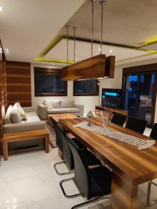 a living room with a large wooden table and chairs at Moumis Luxury Apartment in Limenaria