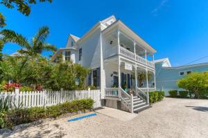 a white house with a white fence and palm trees at CLARO at Azul Mansion Key West in Key West