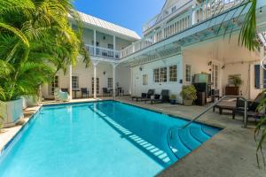 a swimming pool in front of a house at CLARO at Azul Mansion Key West in Key West