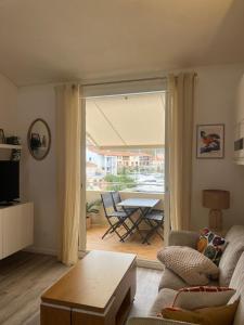 a living room with a couch and a table at Nid du port in Grimaud
