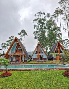 a house with a thatched roof and a pool at Artana cabin in Palayangan