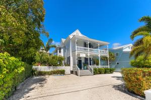 a white house with a white fence and palm trees at CAPTIVA at Azul Mansion Key West in Key West