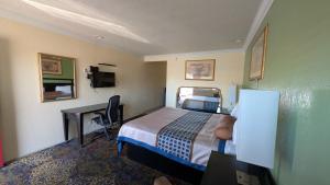 a hotel room with a bed and a desk at Cloud 9 Motel - Cypress, Buena Park in Cypress