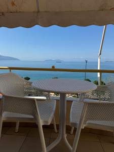 a table and chairs on a balcony with the ocean at Hotel Lungomare in Vlorë