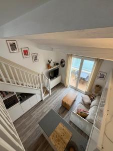 a living room with stairs and a view of the ocean at Nid du port in Grimaud