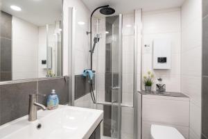a white bathroom with a shower and a sink at Apartment Enjoy in Büsum +12 photos