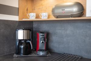 a coffeemaker and coffee maker on a shelf in a kitchen at Apartment Enjoy in Büsum