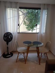 a room with a table and chairs and a window at Casa ampla in Maricá