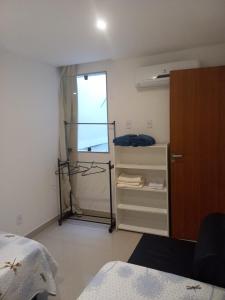 a bedroom with a closet and a bed and a window at Casa ampla in Maricá