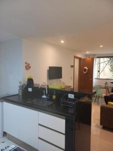 a kitchen with a black counter top and a desk at Casa ampla in Maricá
