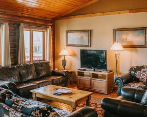 a living room with couches and a flat screen tv at Bar N Ranch in West Yellowstone