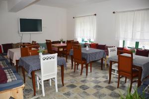 a dining room with tables and chairs and a flat screen tv at Ferma Hodobashi in Çerenisht