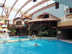 a pool in a hotel with people in the water at Tatralandia Apartman 347 in Liptovský Mikuláš