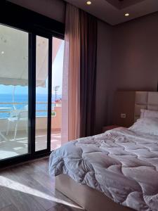 a bedroom with a bed and a view of the ocean at Hotel Lungomare in Vlorë