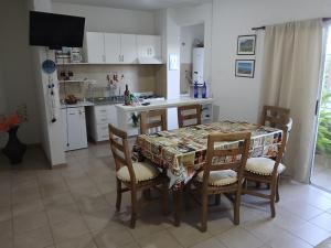 a kitchen with a table and chairs and a kitchen with white cabinets at Casa Chardonnay in Luzuriaga +8 photos