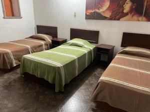 a group of three beds in a room at Casa Brusodia in Guadalajara
