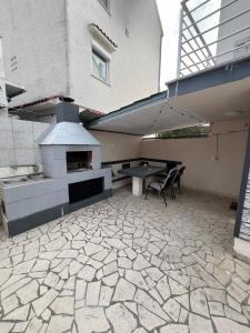 a outdoor patio with a pizza oven and a table at Apartment Boro in Selce