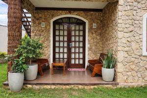 a front porch with two potted plants and a door at Chalé De Canoa in Aracati