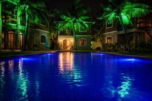 a swimming pool in front of a house with blue lights at Chalé De Canoa in Aracati +2 photos