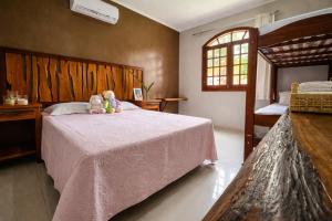 two stuffed animals sitting on a bed in a bedroom at Chalé De Canoa in Aracati