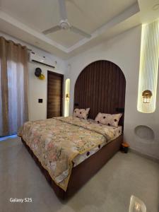 a bedroom with a large bed with a wooden headboard at Eknav Villa in Kharar