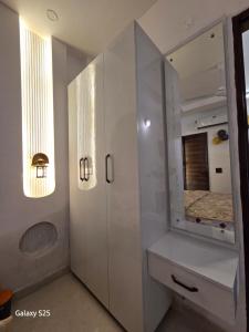 a white bathroom with a sink and a mirror at Eknav Villa in Kharar