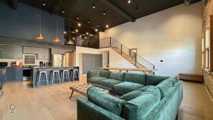 a living room with a couch and a kitchen at Downtown Loft with Rooftop Hot Tub by StayIn in Fernie