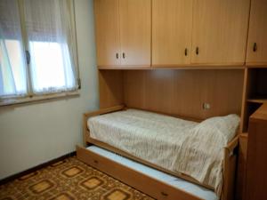 ein Schlafzimmer mit einem Bett in einem Zimmer mit Fenster in der Unterkunft Volano in Lido di Volano