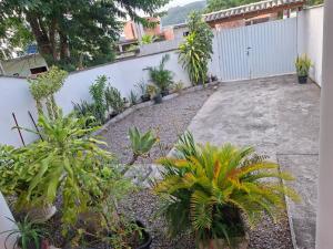 a garden with plants and a white fence at Aconchego em Maricá in Maricá